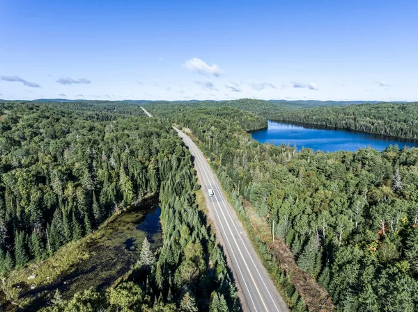 Gyönyörű Kanada táborozó busz vezetés közúti végtelen fenyő erdő tavak moor föld légifelvételek utazási háttérrel — Stock Fotó