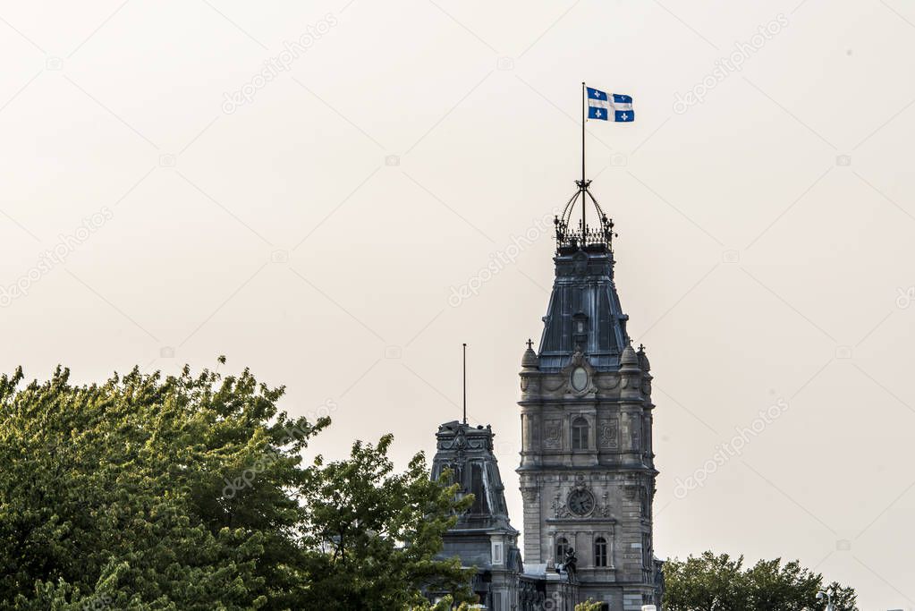 QUEBEC CITY CANADA blue white flag proudly on top of clock tower of parliament building of national assembly of Quebec