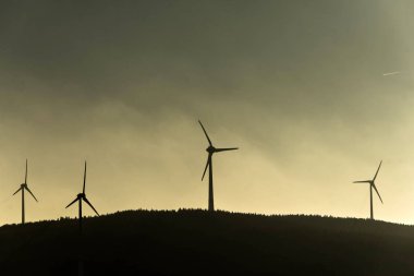 Windturbines enerji jeneratör şaşırtıcı günbatımı üzerinde bir rüzgar çiftliği Almanya gri renkli, siyah silüeti