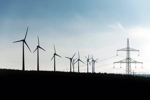 Silhouette nera di turbine eoliche generatore di energia su cielo blu in un parco eolico in Germania — Foto Stock