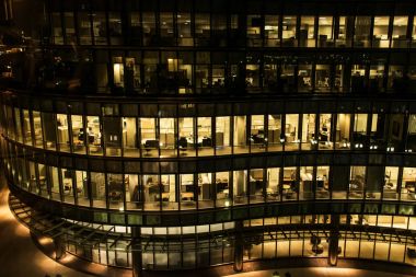 Geceleri geç gece işte, Boston'da bina bir ofisin sarı ışık windows. cam perde duvar ofis binası
