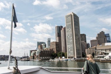 Kadın bir güneşli yaz gününde yelkenli tekneler Boston manzarası önünde Charles Nehri'nde bakarak feribot