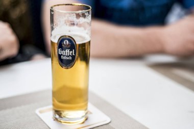Bir bardak gaffel Kölsch şirket logosu bir masada Alman bira