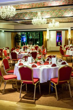 Kırmızı tablo ayarını beyaz masa örtüsü yemekleri gümüş çatal bıçak takımı gözlük ve süslemeleri beyaz kopya metin alanı kartı ile Ziyafet