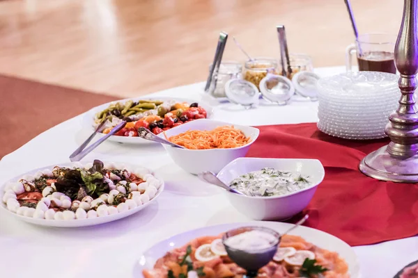 Variety of fresh salads bowls beef and salmon plates on buffet table business dinner — Stock Photo, Image