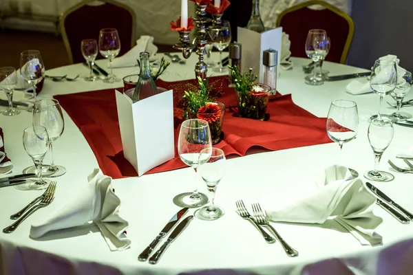 Banquete con mesa roja ajuste mantel platos blancos cubiertos de plata vasos y decoraciones copia blanca tarjeta de espacio de texto — Foto de Stock