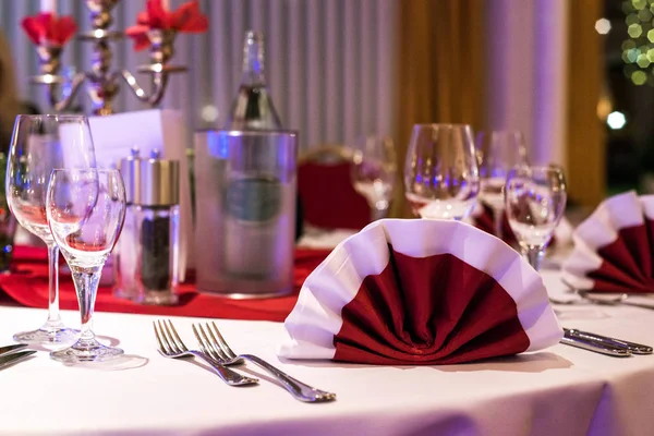 Banquete con mesa roja ajuste mantel platos blancos cubiertos de plata vasos y decoraciones copia blanca tarjeta de espacio de texto — Foto de Stock