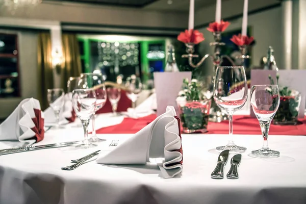 Банкет со скатертью для красного стола белые тарелки серебряные столовые приборы и украшения — стоковое фото