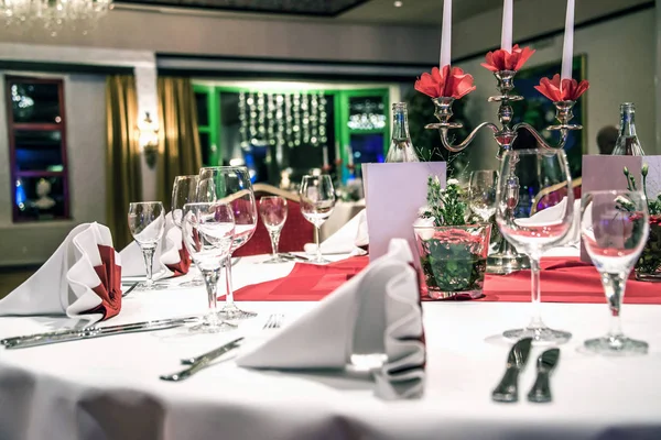 Banquete con mesa roja ajuste mantel platos blancos cubiertos de plata vasos y decoraciones copia blanca tarjeta de espacio de texto — Foto de Stock