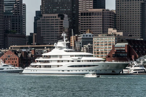 Yacht and sailing boats on Charles River in front of Boston Skyline in Massachusetts USA on a sunny summer day