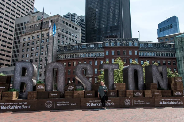 Boston MA USA 04.09.2017 - Muchacha frente a la ciudad de Boston nombre del cartel con Skyline fondo — Foto de Stock