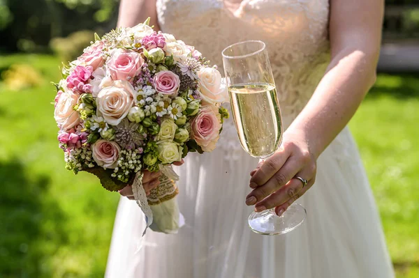 Невеста с букетом цветов и бокалом игристого вина крупным планом свадебного брака — стоковое фото