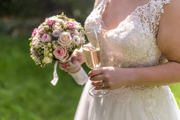 Невеста с букетом цветов и бокалом игристого вина крупным планом свадебного брака — стоковое фото