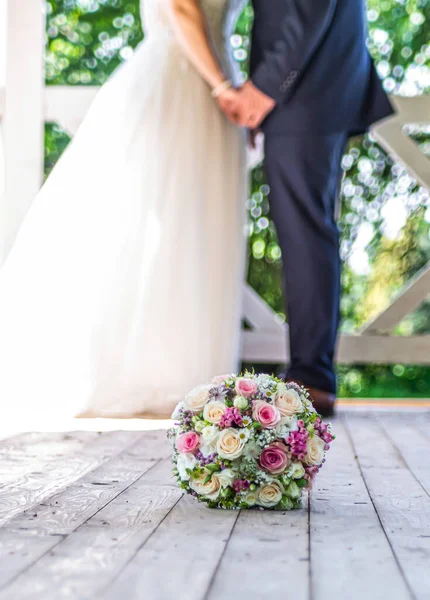 Esküvői csokor előtt friss házasok esküvő pár háttérben, csók vagy kéz a kézben a szerelemben Sekély mélységű bokeh — Stock Fotó