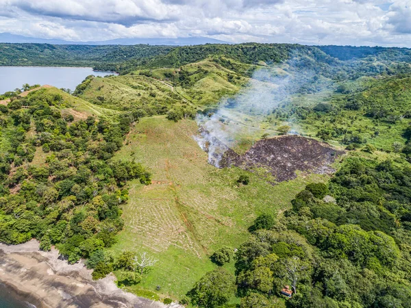 Aerial shot of small fire at the tropical coastline by Playa Arenillas in Costa Rica peninsula Papagayo coast guanacaste — Stock fotografie