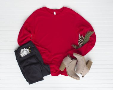 Çizmeli ve kot pantolonlu kırmızı tişört. Çam kozalakları maket yapar