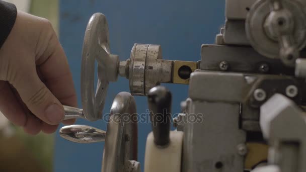 Arbeiter steuert Verstellrad der Drehmaschine — Stockvideo