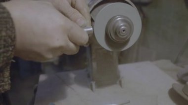 İşçi aracın keskinleştirir. Bir keskinleştirme makine üzerinde çalışmak.