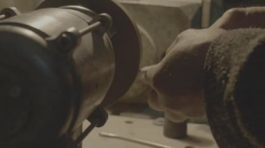 İşçi aracın keskinleştirir. Bir keskinleştirme makine üzerinde çalışmak.