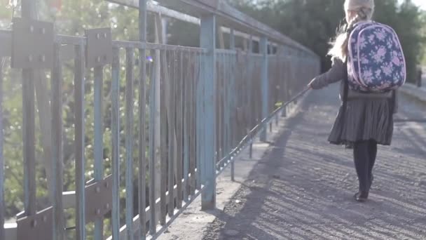 Girls bangs with stick on the fence on the bridge — Stock Video