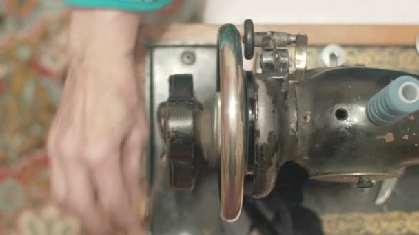 Old woman sews jeans on old style seving machine — Stock Video