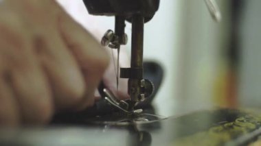 Yaşlı kadın eski stil seving makine üzerinde kot pantolon diker