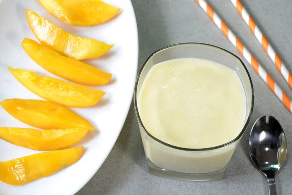 Mango Milkshake Szklanym Kubku Świeżo Krojone Mango Talerzu — Zdjęcie stockowe