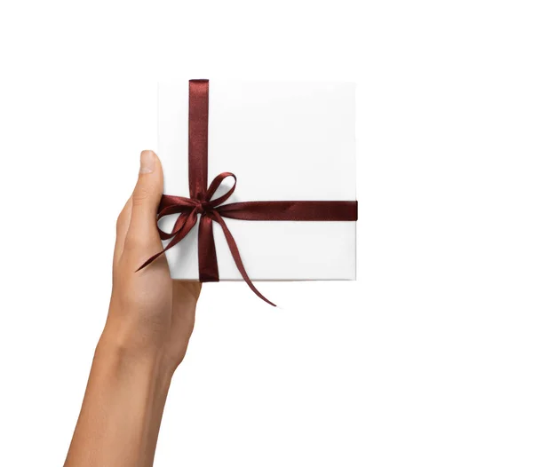 Isolato donna mani che tengono vacanze regalo scatola bianca con nastro marrone su uno sfondo bianco — Foto Stock