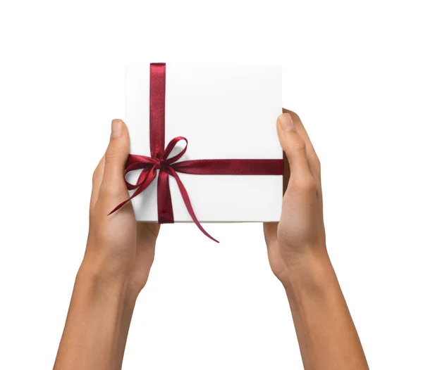 Isolato donna mani in possesso di vacanza regalo scatola bianca con nastro rosso su uno sfondo bianco — Foto Stock