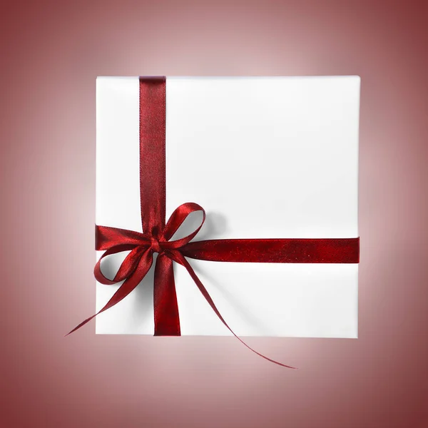 Isolado Holiday Presente caixa branca com fita vermelha em um fundo gradiente — Fotografia de Stock