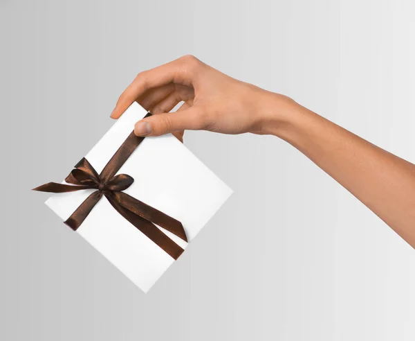 Mujer de mano celebración de vacaciones regalo caja blanca con cinta marrón — Foto de Stock