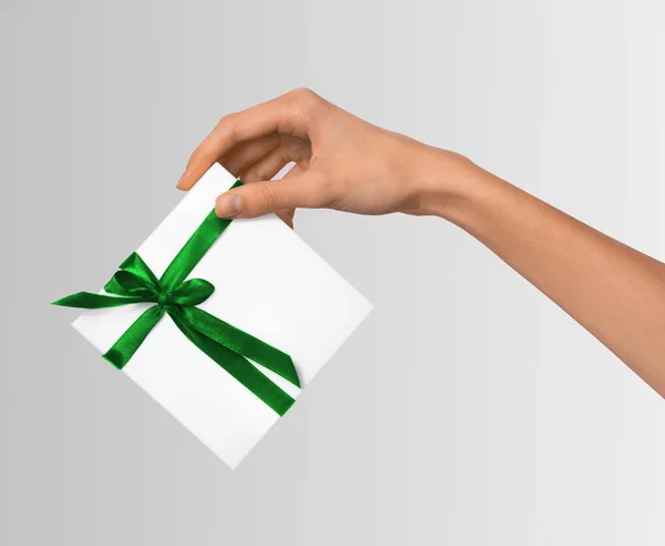Mujer de mano celebración de vacaciones regalo caja blanca con cinta verde — Foto de Stock