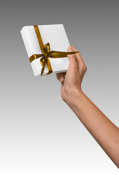 Kobieta ręce trzymając Holiday Present Box biały z żółtego złota wstążka — Zdjęcie stockowe