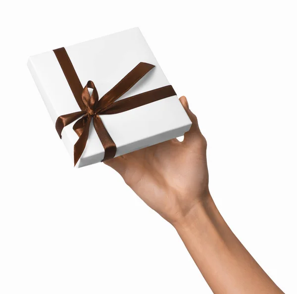 Женщина держит в руках праздничный подарок белый ящик с коричневой лентой — стоковое фото