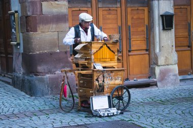 Bir adam fıçı org çalıyor.
