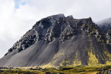 İzlanda 'da doğa manzarası. Siyah lav dağı manzaralı, etrafta insan yok..