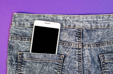 Yakın kadar Bussines moda şık akıllı telefon ekran kopya alanı beyaz içinde hareket eden siyah kot geri cep Denim Hipster ultra violet eğilim renk arka plan üzerinde