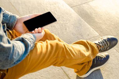 Yakın kadar Hipster iş adamı kullanarak akıllı cep telefonu App açık siyah Oled ekran arka plan kaldırım taşı şık Dressed