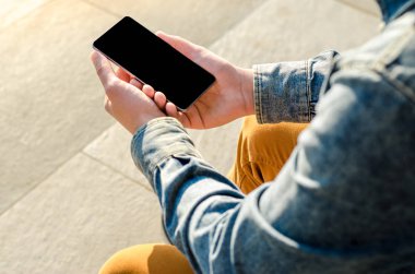 Yakın kadar Hipster iş adamı kullanarak akıllı cep telefonu App açık siyah Oled ekran arka plan kaldırım taşı şık Dressed