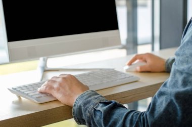 Kişisel bilgisayar ahşap masa masaüstü ofis pencere gökdelen oturan çalışma iş adam üstten görünüm kadar kapatın. Erkek yazarak bilgisayar klavye kullanarak eller. Genç girişimci başında çalışma.