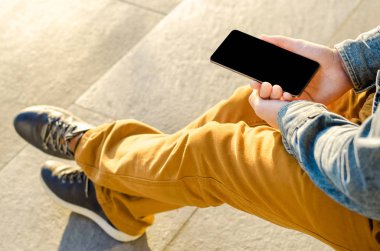 Yakın kadar Hipster iş adamı kullanarak akıllı cep telefonu App açık siyah Oled ekran arka plan kaldırım taşı şık Dressed