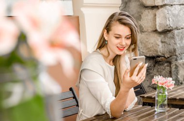 Uzun saçlı smartphone kafe şehir sokak güneşli gün arka planda tutan gülümseyen iş casual kadın portresi
