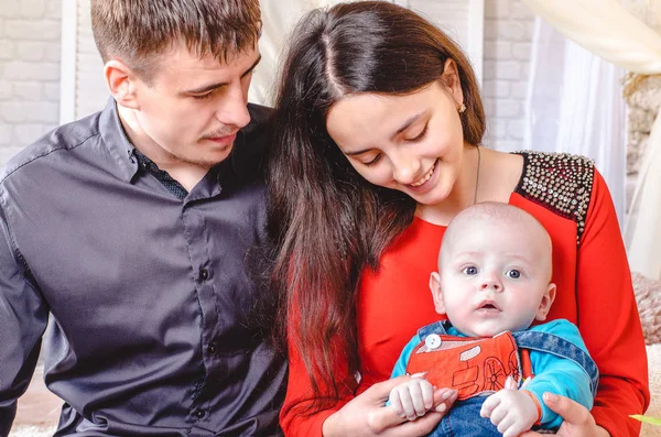 Joven Mama Y Papa Sanos Sosteniendo Hijo Recien Nacido En Las Manos En El Fondo De La Sala De Chaild Feliz Familia Joven Sonriente Nino Mantenimiento Stock Photo