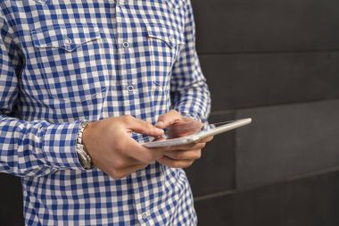 Erkek el genç hippi çocuk dışında modern dijital tablet şık gömlek kullanarak yakın çekim