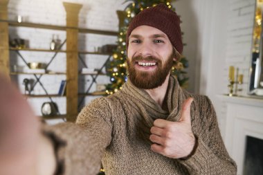 Noel partisinde Noel ağacı ile selfie yapma yakışıklı delikanlı. Online smatphone ile konuşan adam veya yeni yıl partisi üzerinde tablet. Kutlama arkadaş. Her zaman online kavramı.