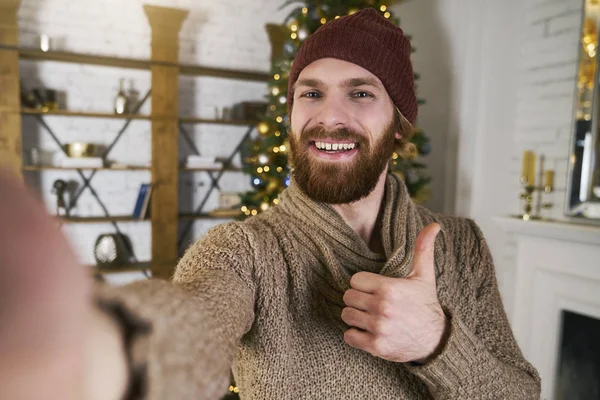 Noel partisinde Noel ağacı ile selfie yapma yakışıklı delikanlı. Online smatphone ile konuşan adam veya yeni yıl partisi üzerinde tablet. Kutlama arkadaş. Her zaman online kavramı.