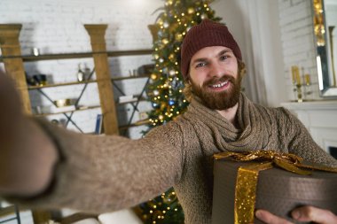 Noel partisi hediye onun elinde selfie yapma yakışıklı delikanlı. Online smatphone ile konuşan adam veya yeni yıl partisi üzerinde tablet. Kutlama arkadaş. Her zaman online kavramı.