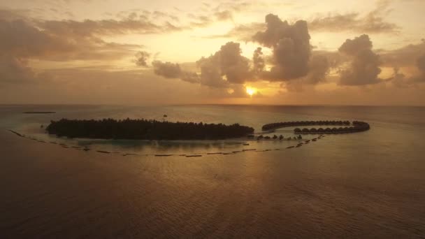 島の豪華な水上ヴィラと海に沈む夕日の空中写真 — ストック動画