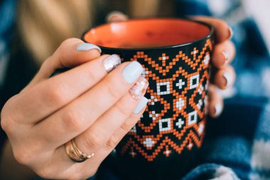 Güzel bir süs ve güzellik ile kızın elinde kahve portakal bir fincan