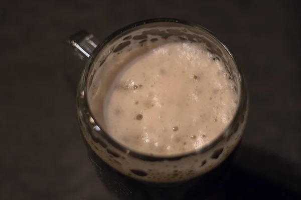 Espuma de cerveza oscura en un vaso — Foto de Stock